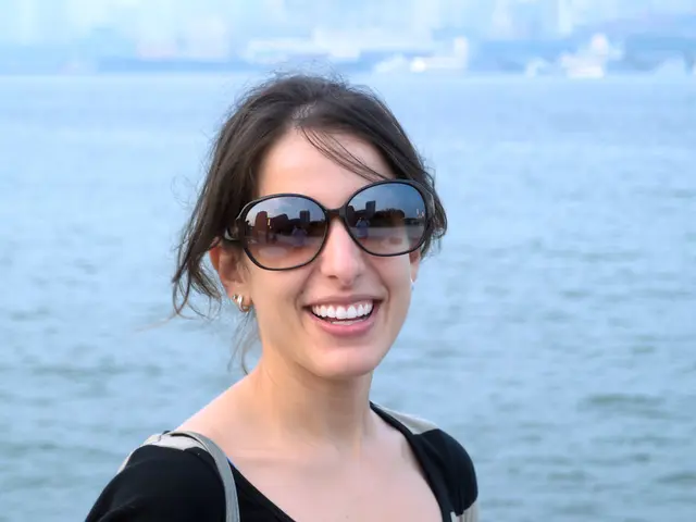 In the center of the image we can see a lady smiling. She is wearing goggles. In the background...