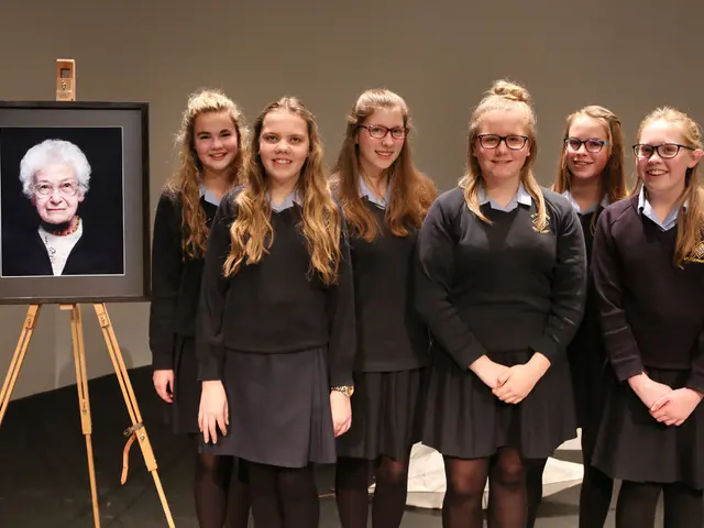 In this picture there are women standing and smiling, behind these women we can see white object on...