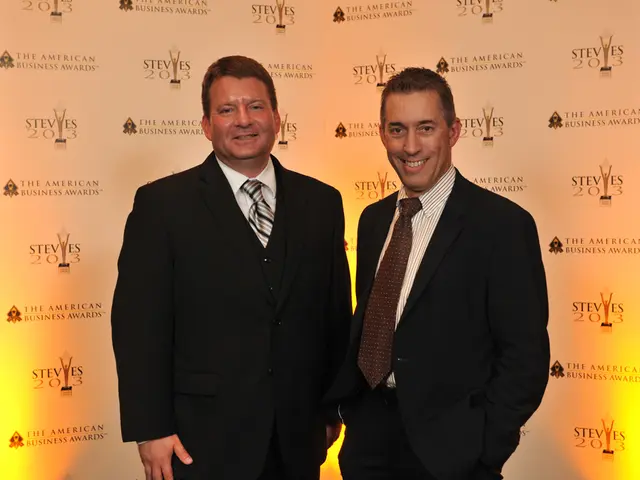 In this image in the center there are persons standing and smiling. In the background there is a...