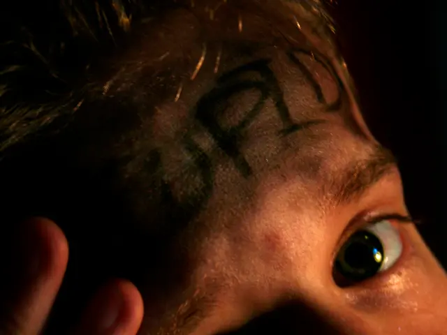 In this image, we can see a person and there are some letters written on his head.