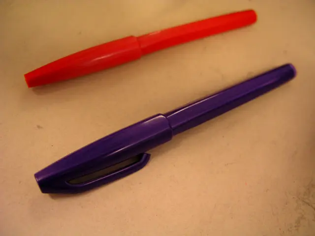 In this image, I see 2 pens and one of them is in violet color and the another one is of red in...