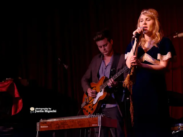 In this picture we can see a lady who is Standing and holding a mic and beside her there is a guy...